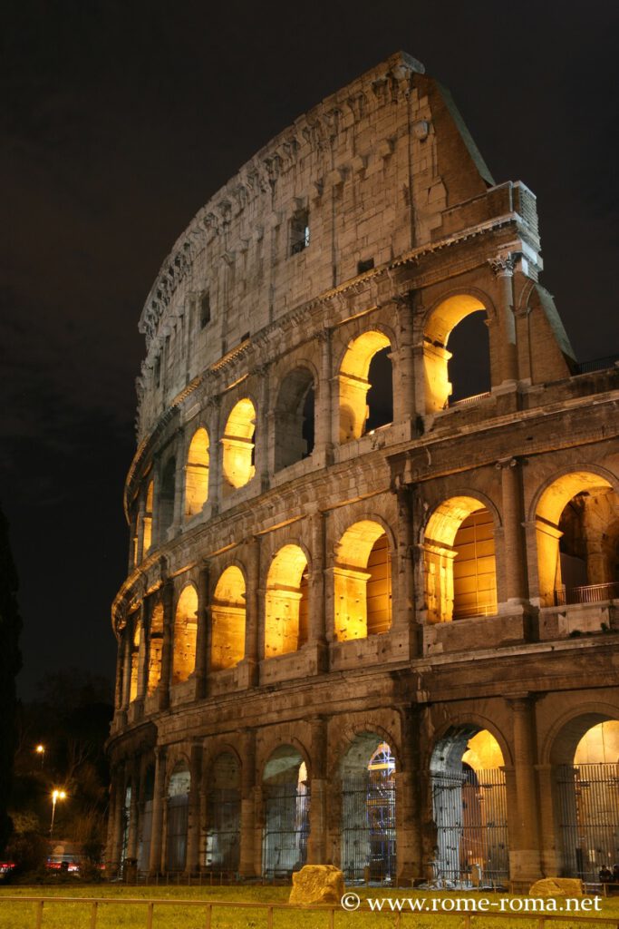 Photo du Colisée de Rome de nuit éclairé avec des lumières orangées